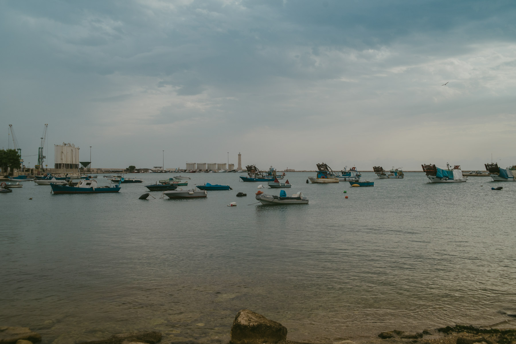 Il porto a barletta con barche piccole in una giornata calma e grigia e nuvolosa - The harbour of Barletta with small ships during a grey moody and cloudy day