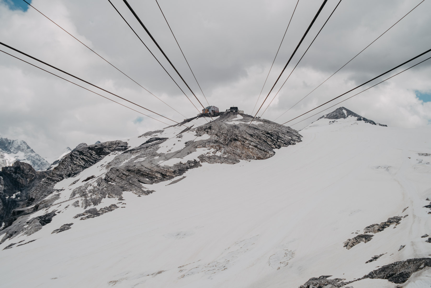 Summer snow on the mountains near the Stelvio pass with cables of the cableway in sight, Neve estiva sulle montagne del passo dello Stelvio con i cavi della funivia